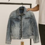 Flat lay of denim jacket with jeans, t-shirt, and accessories styling guide