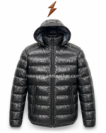 Leather puffer jacket detail showing attached hood, glossy black leather surface, horizontal quilting, zipper pocket, and elastic cuff.
