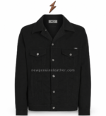 Black denim jacket manufacturer pocket detail with reinforced stitching and bronze-tone hardware