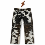 NGL cowhide pants front view with natural black and white pattern, curved pockets, metal rivets, and knee-panel stitching